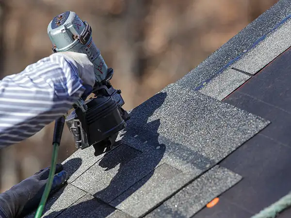 Roofer installing new shingles
